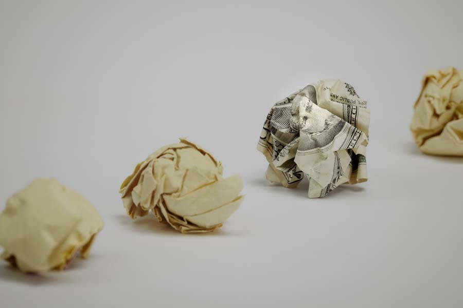 Crumpled dollar bill among office paper.